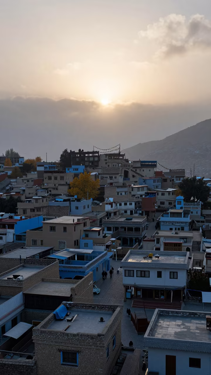 Leh Rooftops Before Sunrise in Autumn in on a wind-cut ridge below prayer flag lines near Leh
