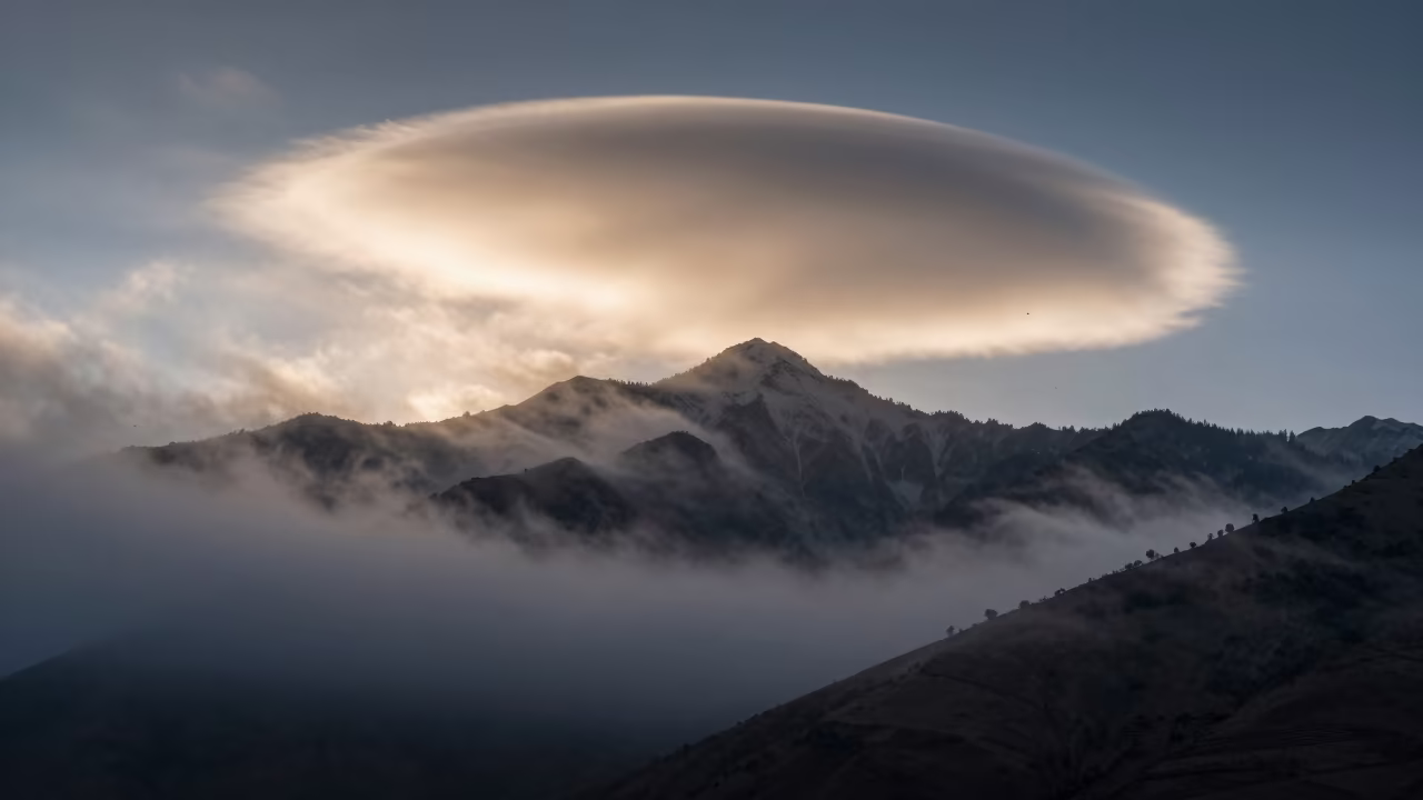 Lenticular Cloud Silhouette Kashmir Twilight in through low marine fog in Kashmir