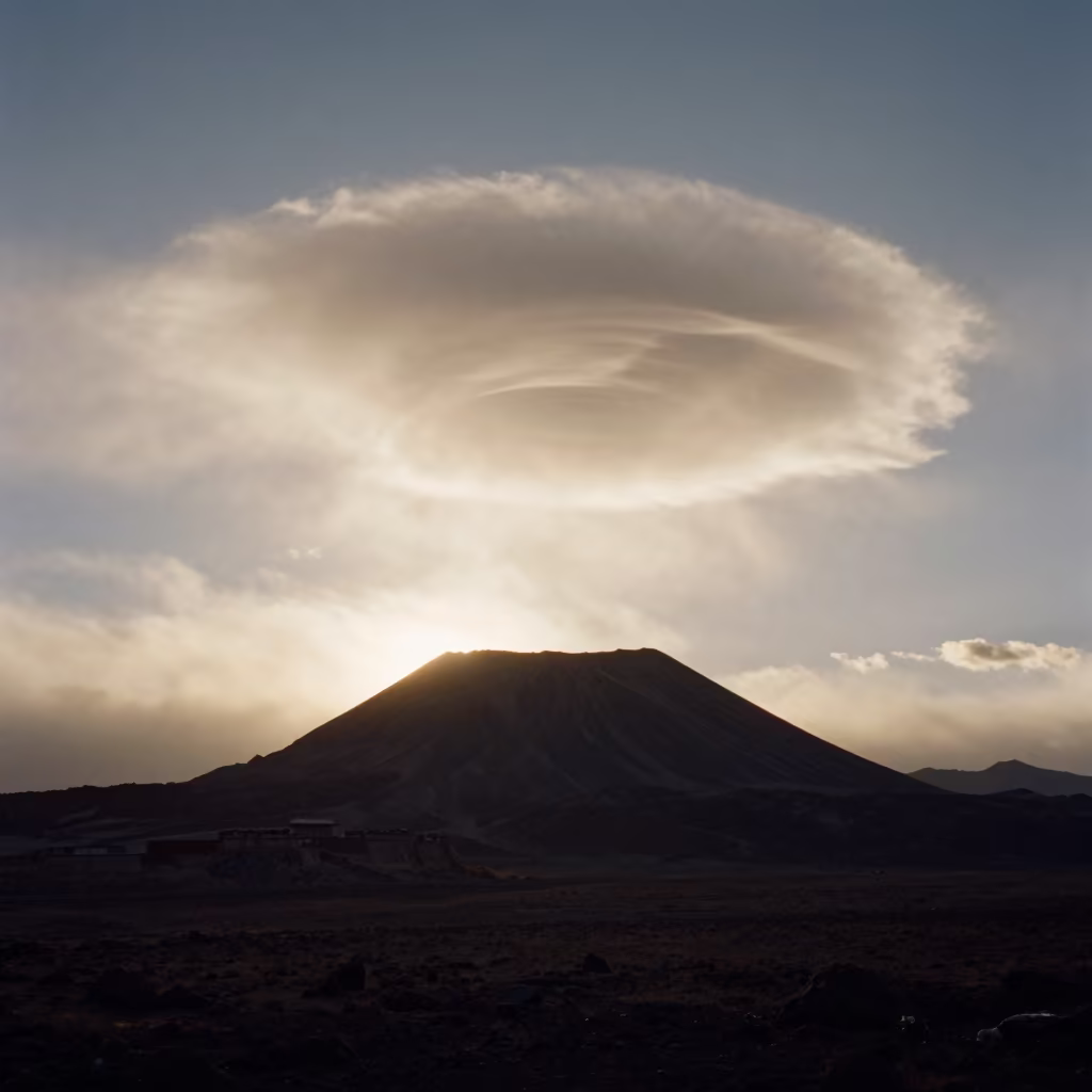 Lenticular Cloud Over Volcanic Peak at Sunset in beneath fast-moving cloud bands near Lhasa