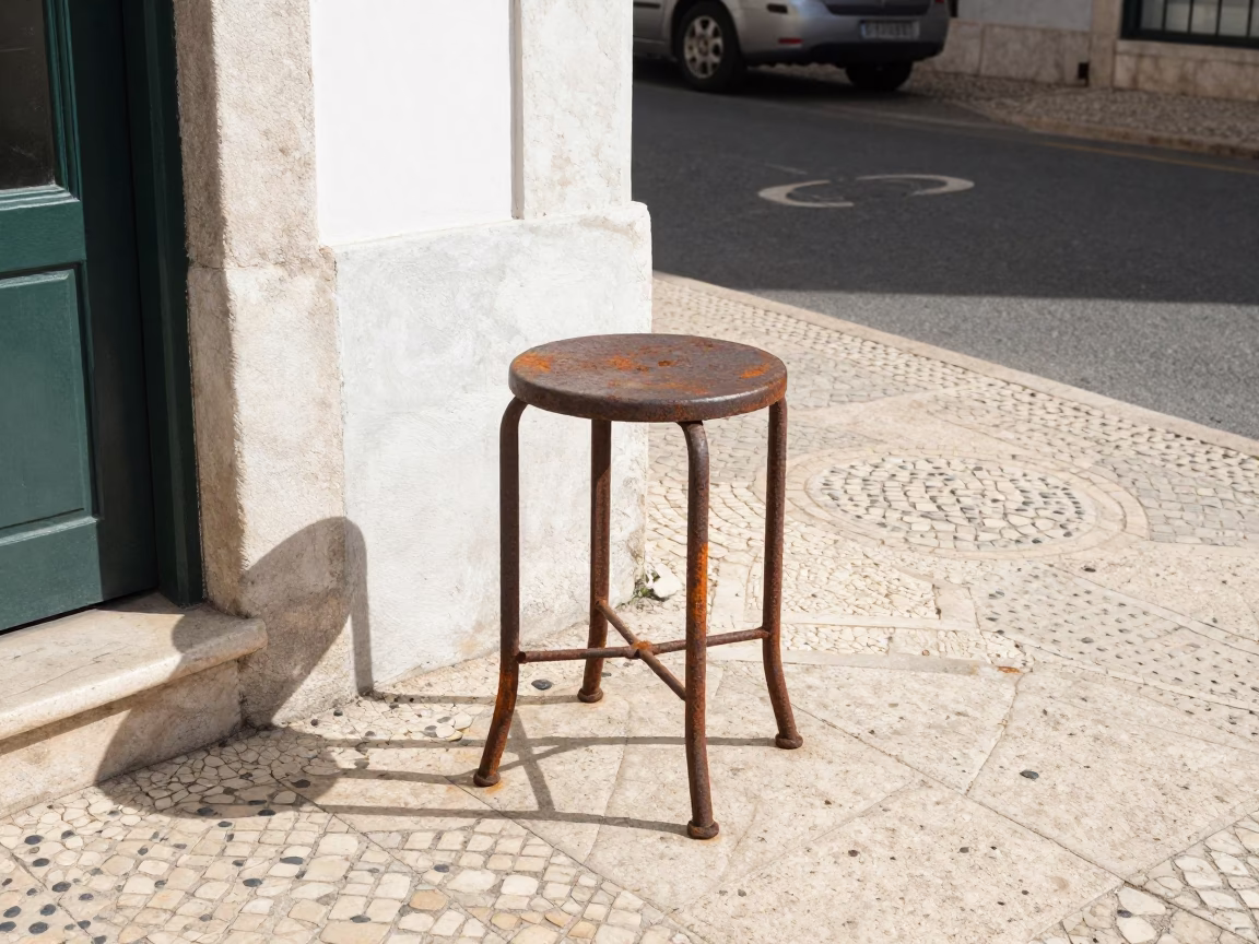 Lisbon Portugal Midmorning Street Scene with Rusty Metal Stool and Pomegranate in in Lisbon, Portugal