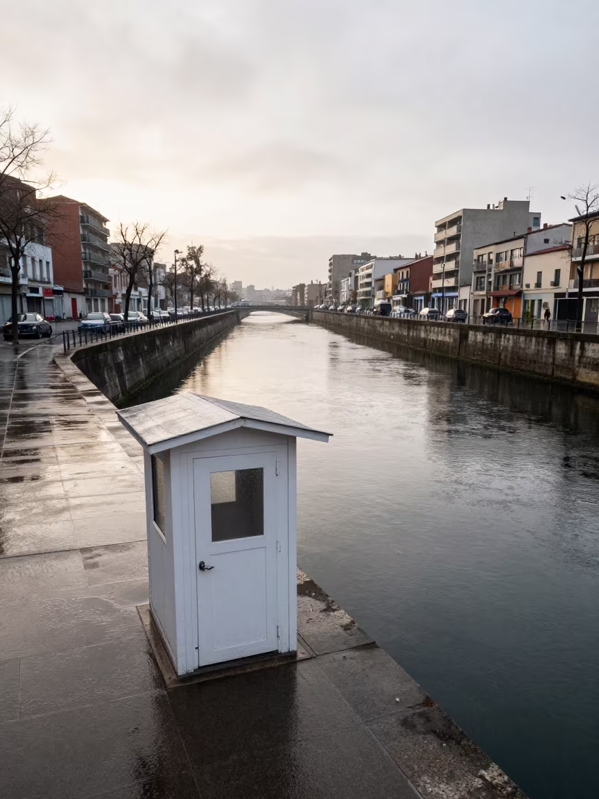 Lock Keeper Cabin Beside Still Black Water Before Dawn in along a levee path above floodwater in Barcelona