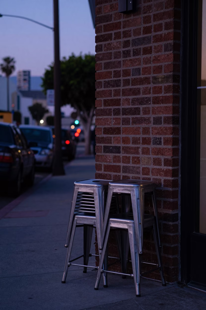 Los Angeles Indigo Twilight Street Scene with Metal Stools and Oil-Sheen Puddles in in Los Angeles, California, United States