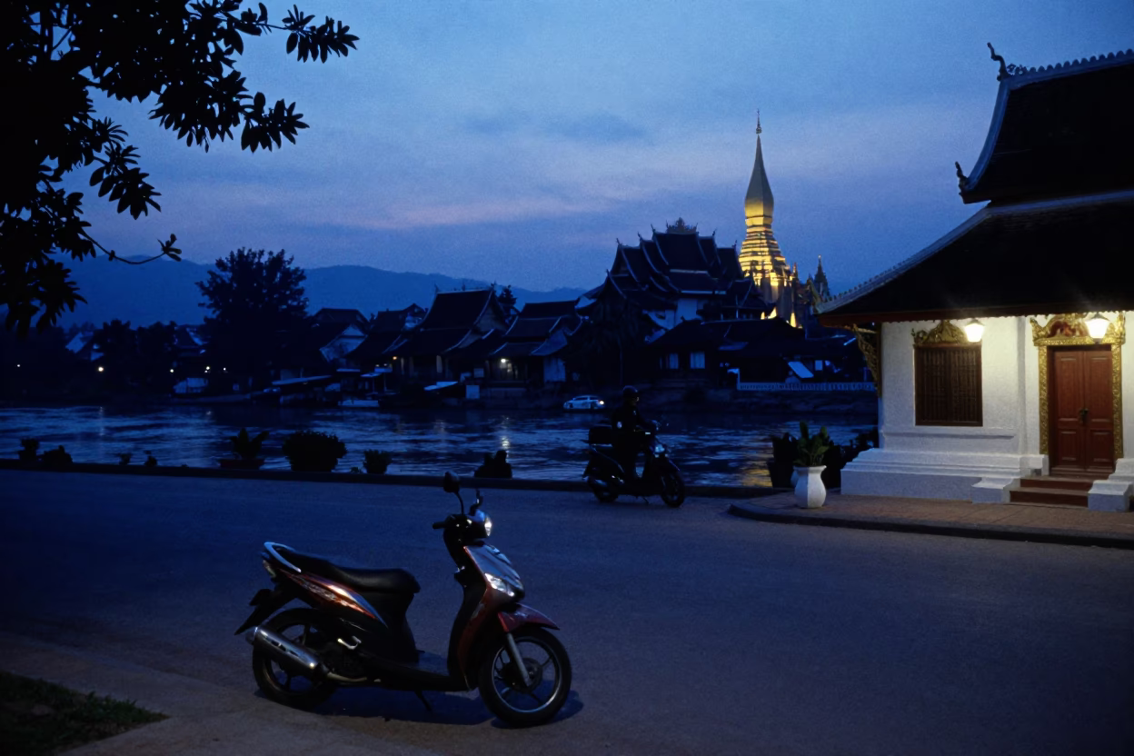 Luang Prabang Laos Indigo Twilight Street Scene with Scooter and Temple Silhouette in in Luang Prabang, Laos
