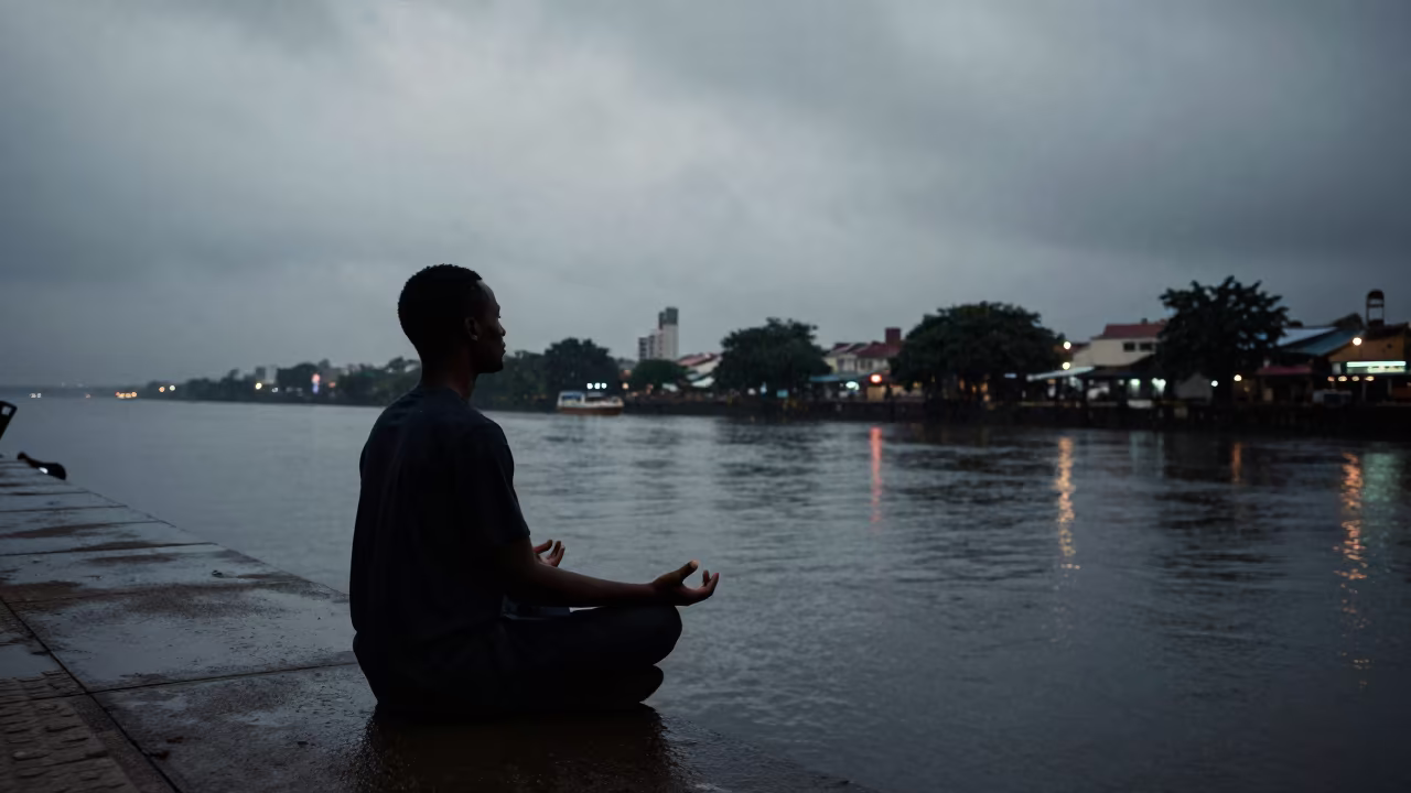 Silhouette of Man Meditating by Lagos Canal in beside a canal in Lagos