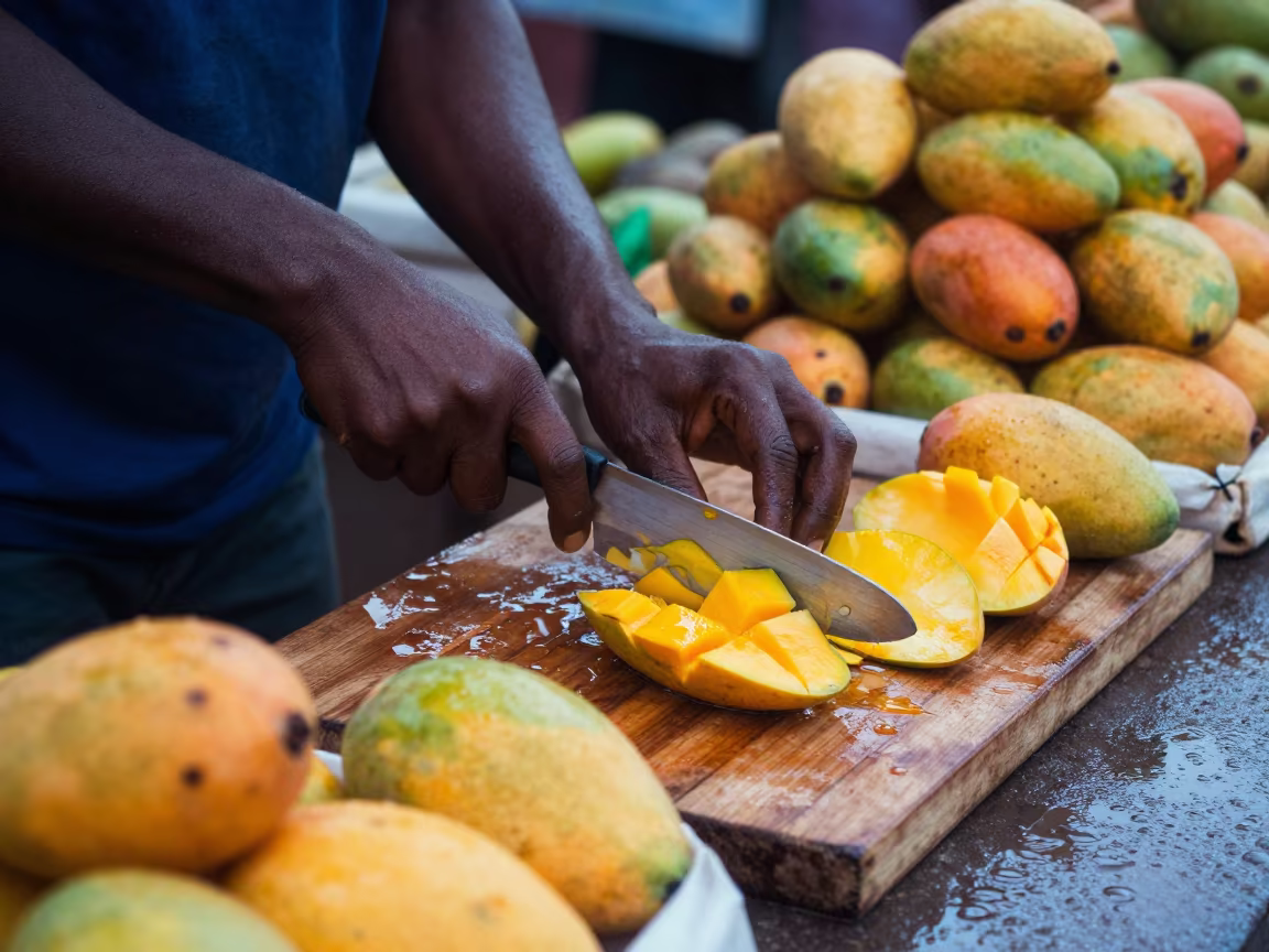 Mango Vendor Slicing Fruit at Abuja Market in at a roadside fruit stand in Abuja