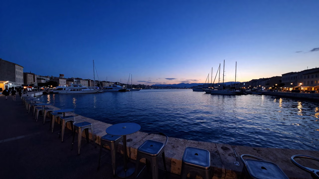 Marseille Old Port indigo twilight metal stools and harbor activity in in Marseille, France