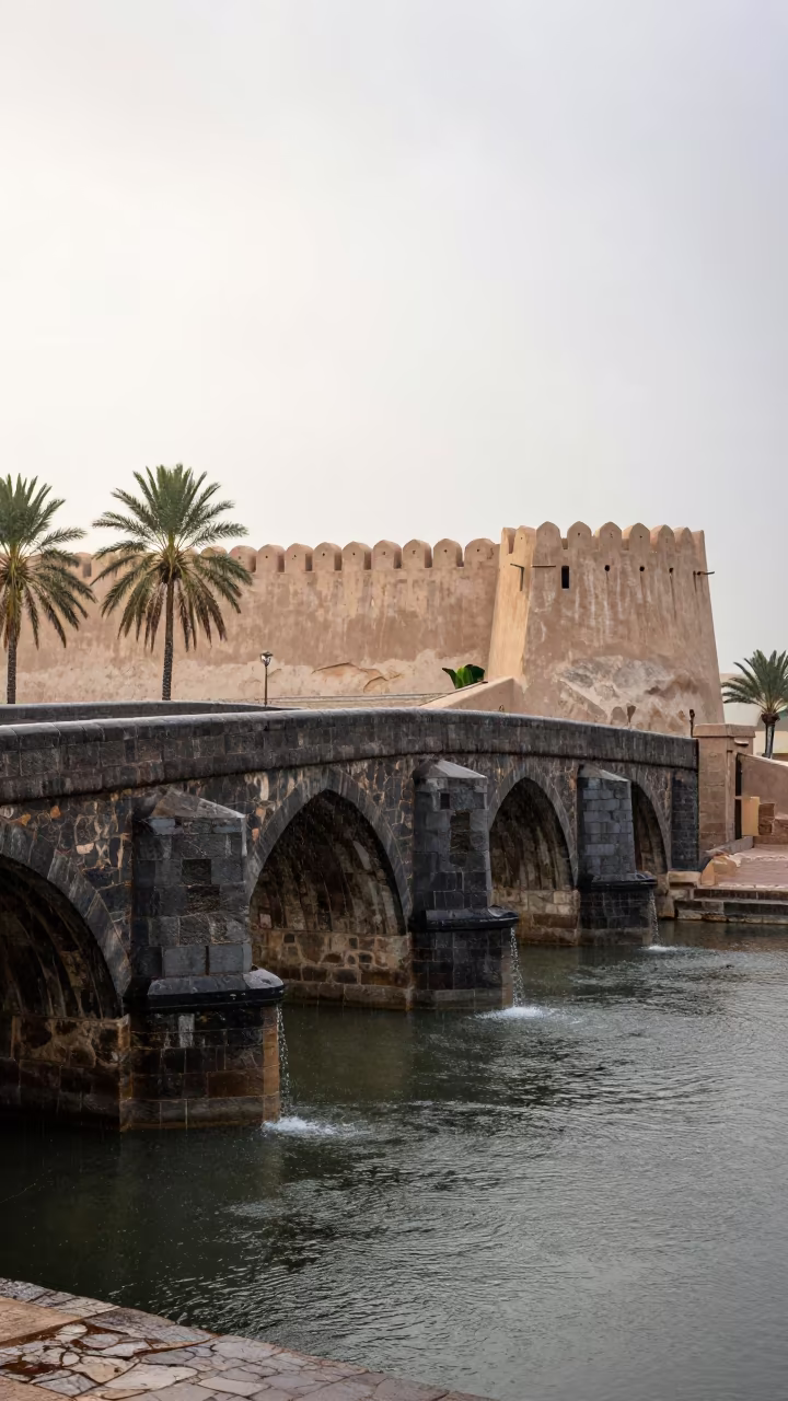 Medieval Stone Bridge Beside Fortress Wall UAE in outside a wind-scoured fortress wall in United Arab Emirates