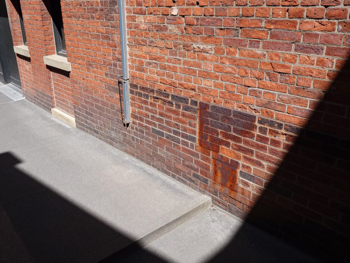 Melbourne Laneway Brick Wall Rust and Concrete Steps at High Noon in in Melbourne, Victoria, Australia
