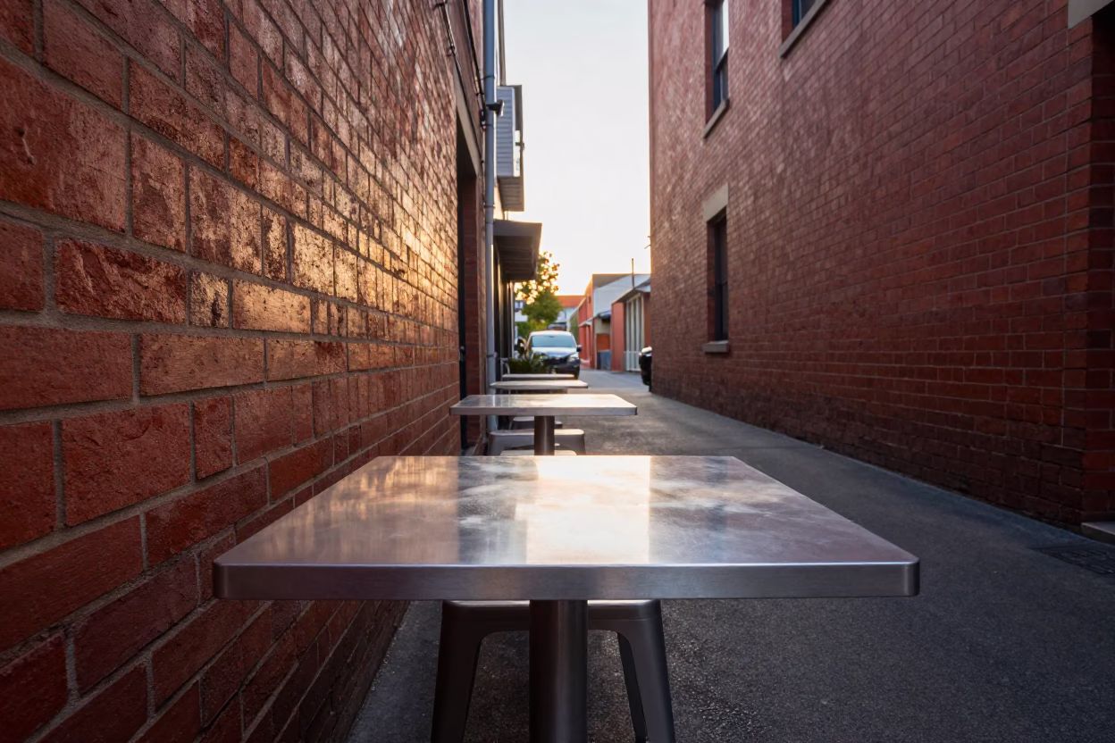 Melbourne laneway morning light with brushed steel table and window hinge detail in in Melbourne, Victoria, Australia