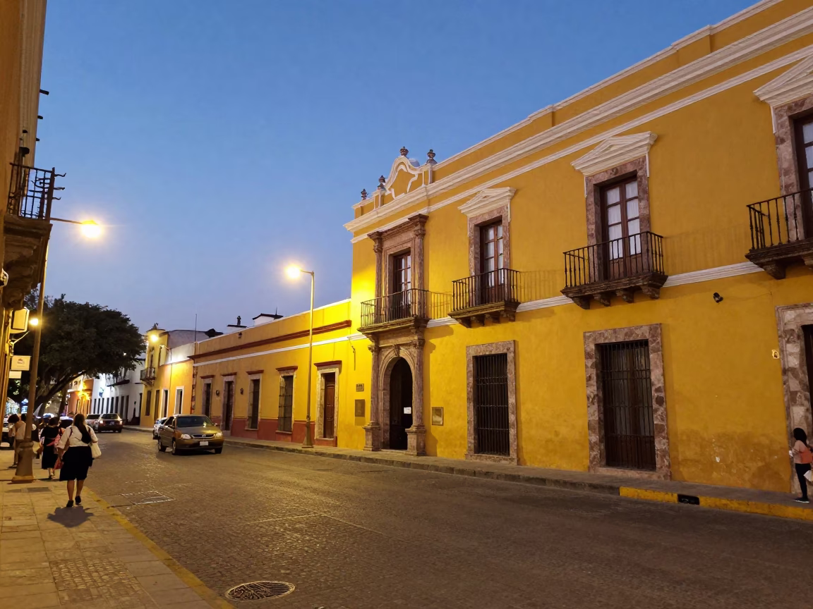 Merida Mexico Street Scene at Dusk with Yellow Colonial Buildings and Evening Traffic in in Merida, Mexico