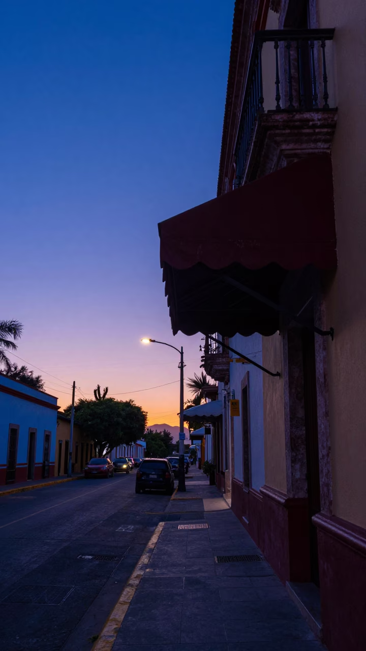 Merida Mexico street scene before sunrise with hotel awnings and headlight reflections in in Merida, Mexico