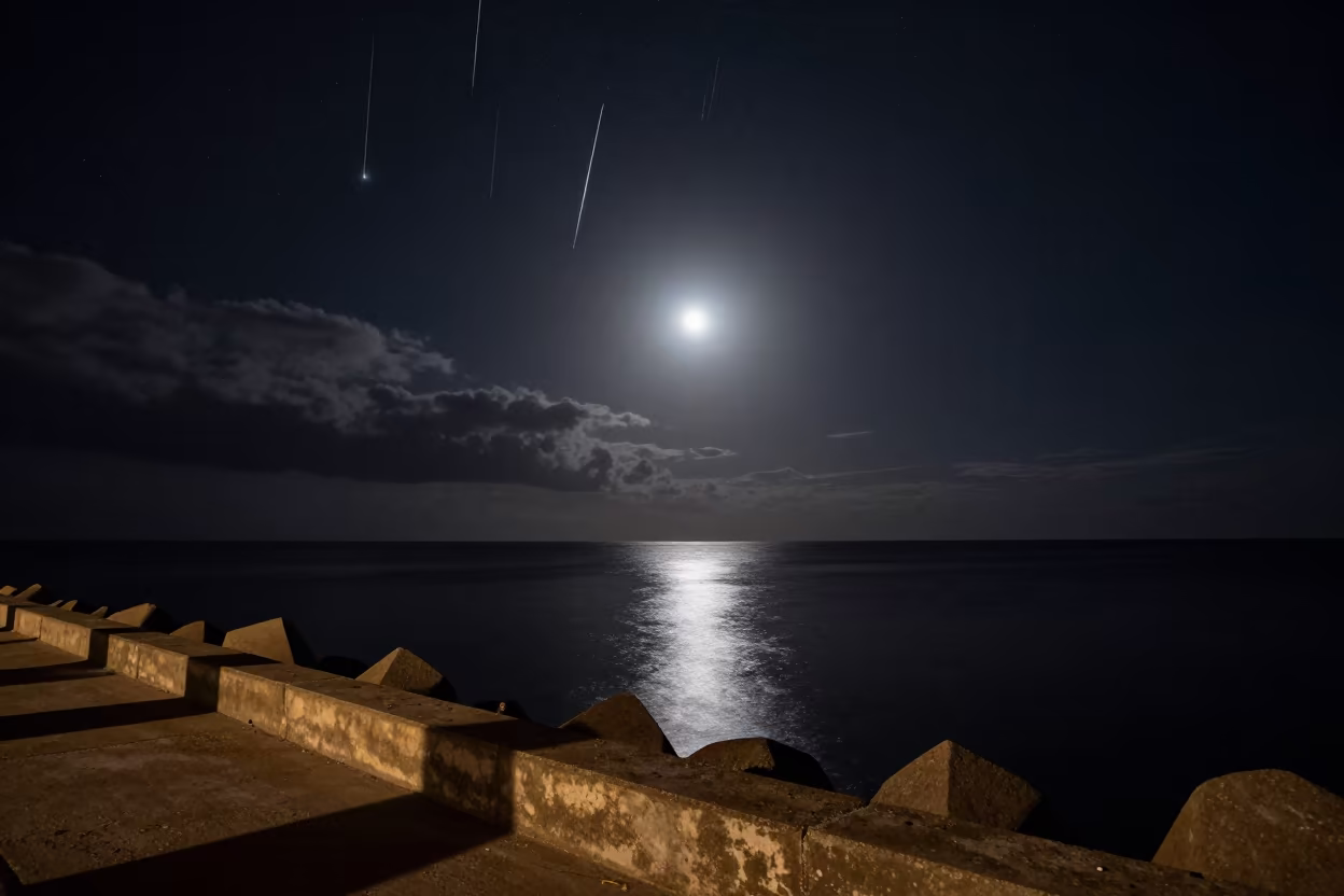 Meteor Shower Reflections on Senegal Ocean in from a moonlit breakwater in Senegal