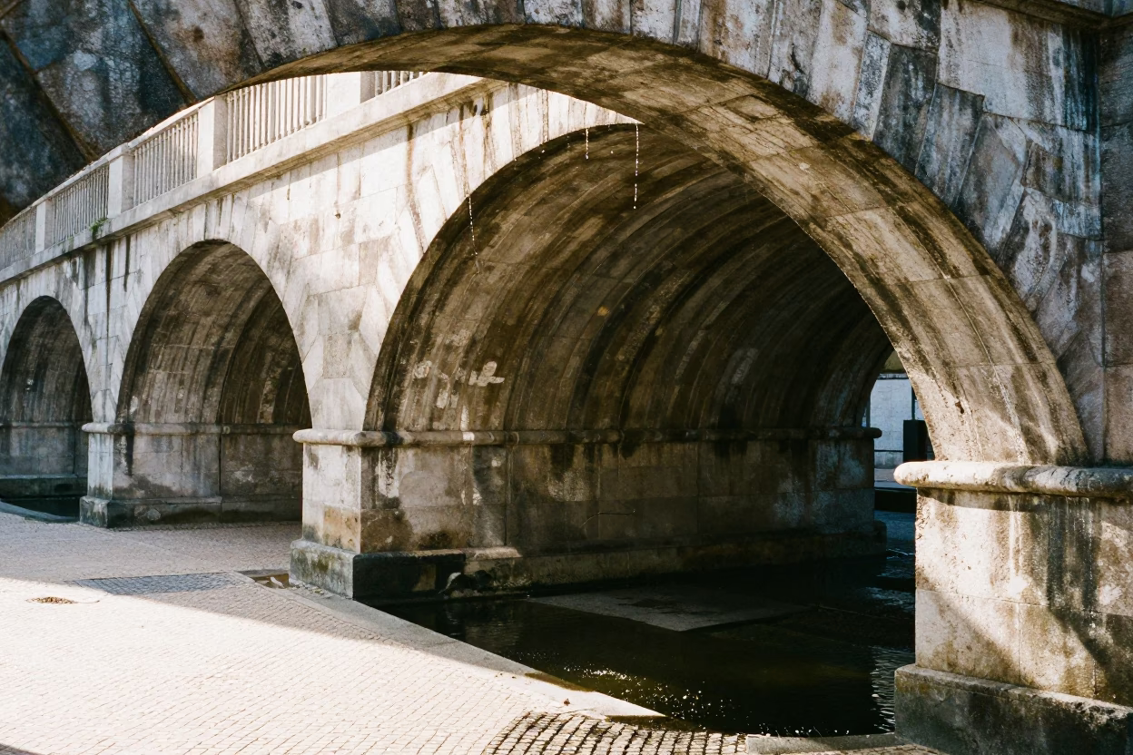 Midday Sunlight on Lisbon Viaduct Arch Undercroft Dripping onto Ferny Stone in Portugal in in Lisbon, Portugal