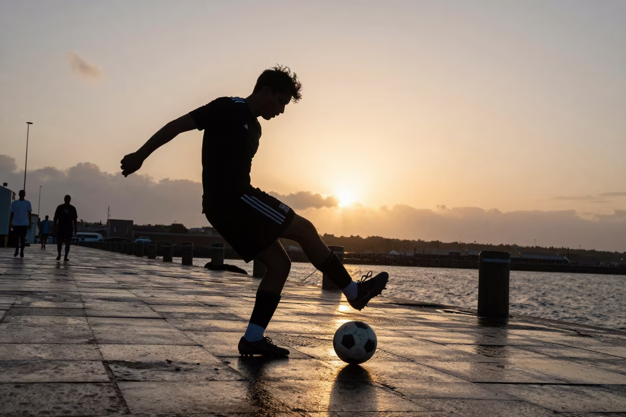 Silhouetted Midfielder Chipping Ball Over Harbor Defense in at a harbor quay near Adzopé