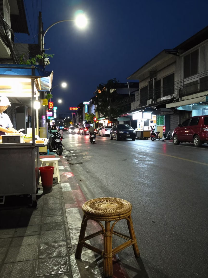 Midnight Bangkok Street Scene with Rattan Stool and Neon Reflections in in Bangkok, Thailand