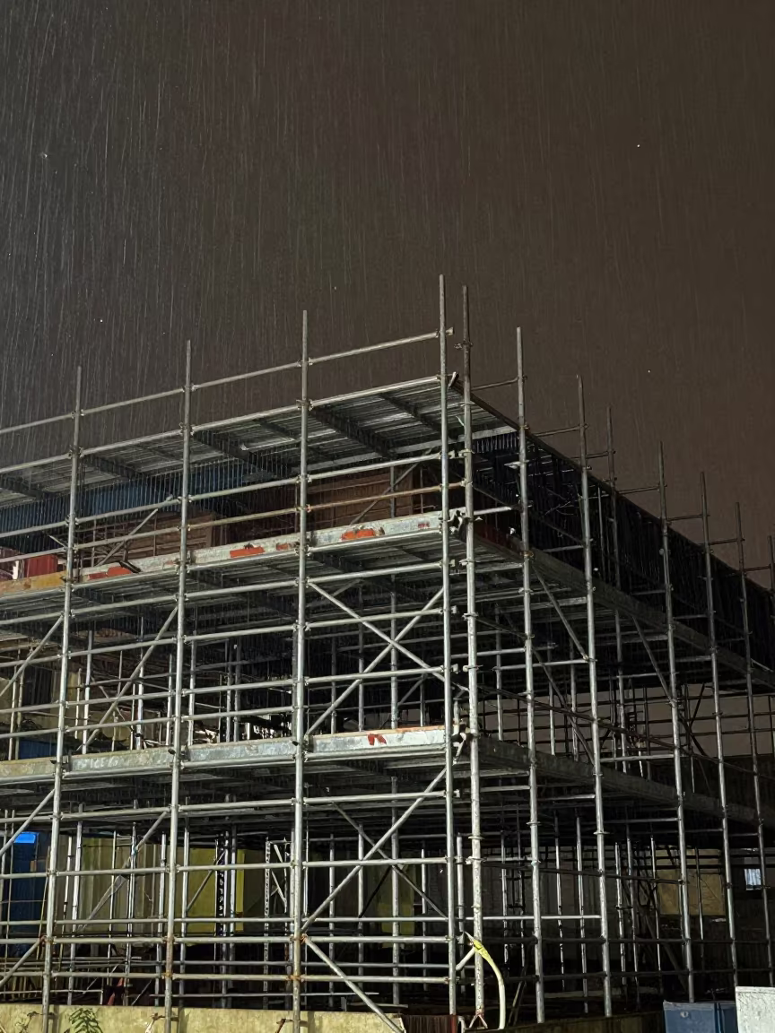 Midnight Scaffolding in Tanzanian Rain in beside exposed structural steel in Tanzania