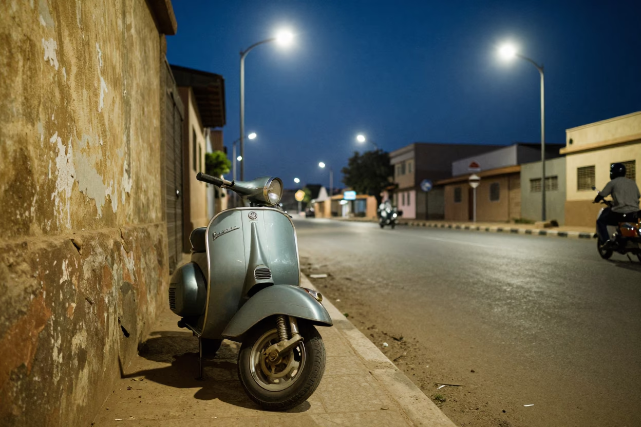 Midnight Street Scene in Dakar Senegal with Vintage Vespa and Substation Fence in in Dakar, Senegal