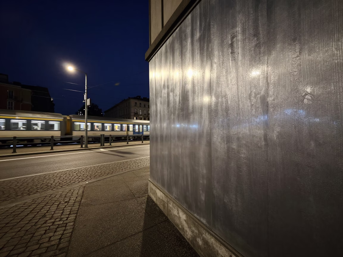Midnight Street Scene in Milan with Brushed Steel Plaster Wall and Night Train Reflections in in Milan, Italy
