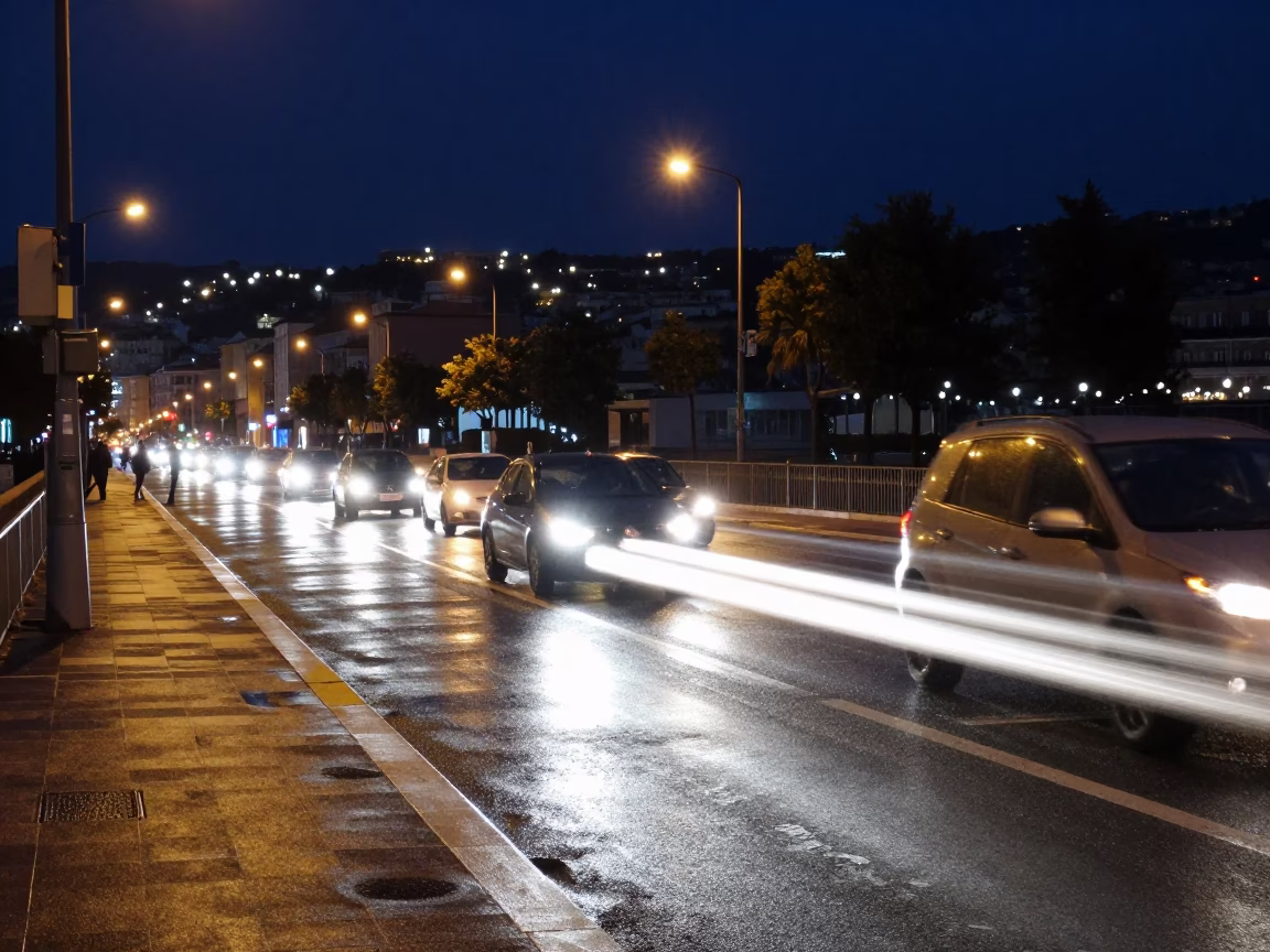 Midnight street scene in Nice France with long exposure car headlights and rainy puddles in in Nice, France