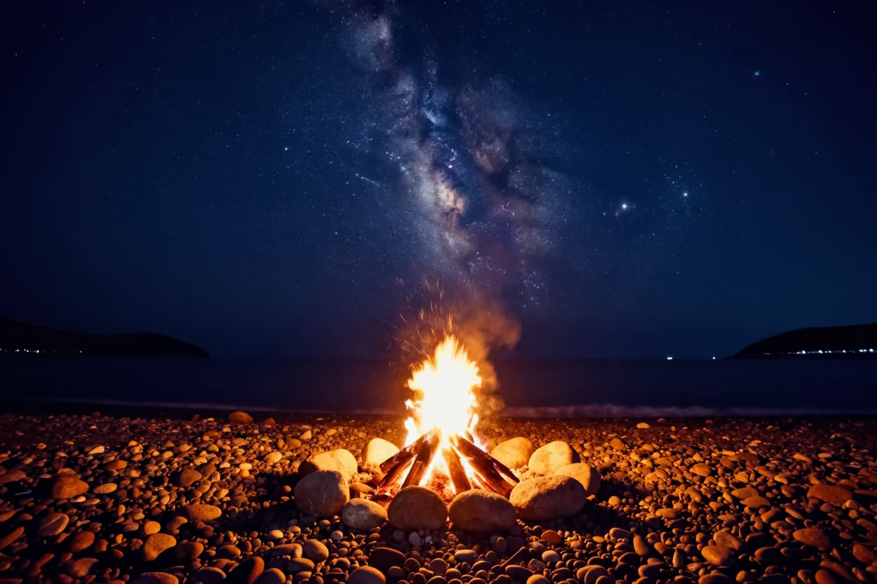 Milky Way Over Bonfire on Busan Pebble Beach in beneath thin cloud gaps and stars near Busan