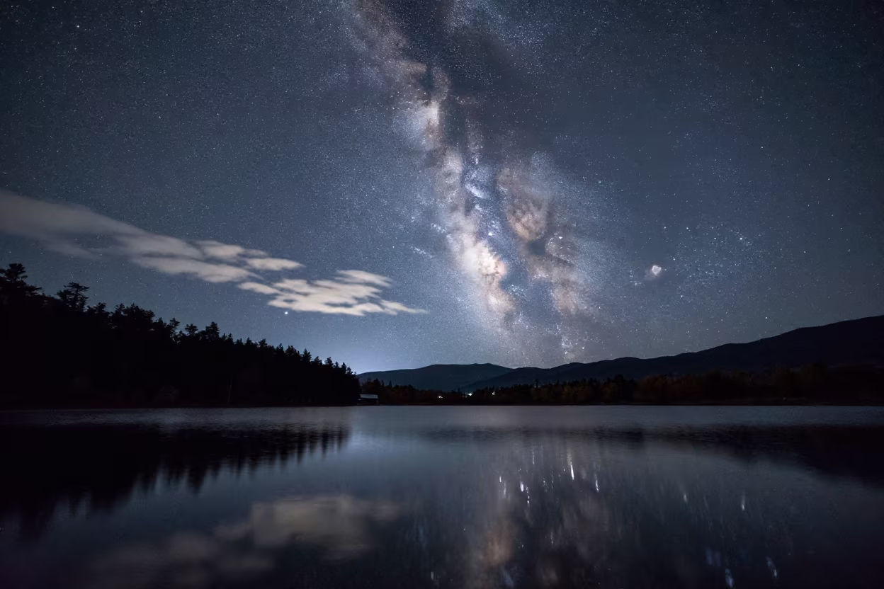 Milky Way Reflected in Still Alpine Lake Yunnan in beneath thin cloud gaps and stars in Yunnan