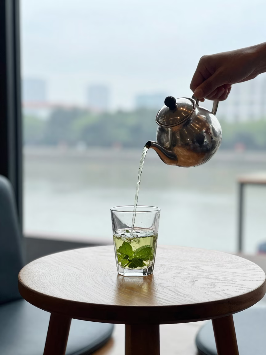 Mint Tea Poured High in Guangzhou Cafe in on a small cafe table by a window in Guangzhou