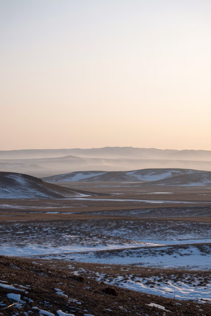 Mongolian Desert Basin Snow at Dawn in across a wide valley floor in Mongolia