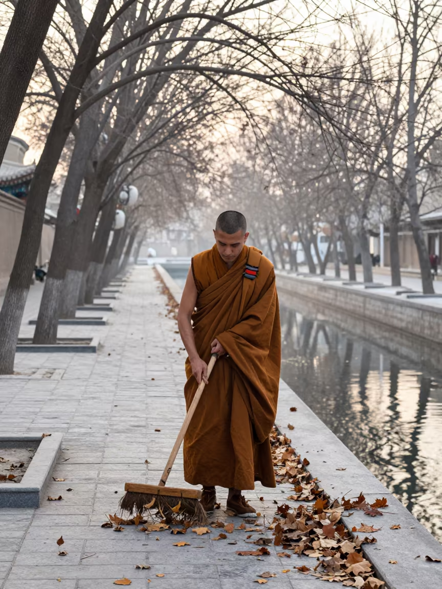 Monk Sweeping Leaves at Winter Dawn in beside a canal in Ashgabat