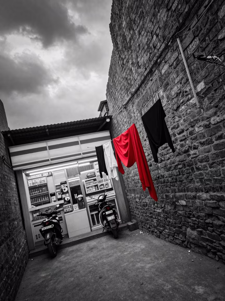 Monochrome Alley With Red Scarf in Larkana in outside a fluorescent convenience store in Larkana