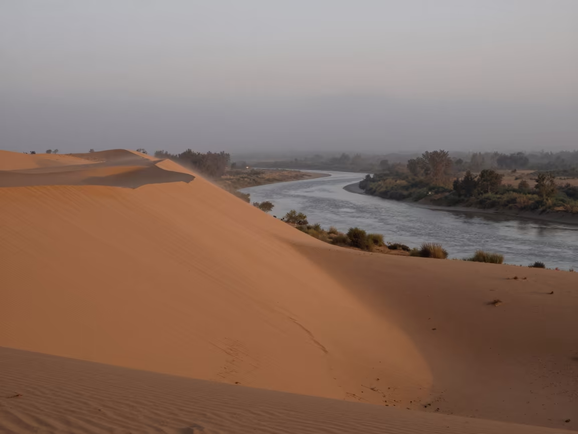 Monsoon Dune Beside Silver River at Dusk in across a wide valley floor near Bimbo