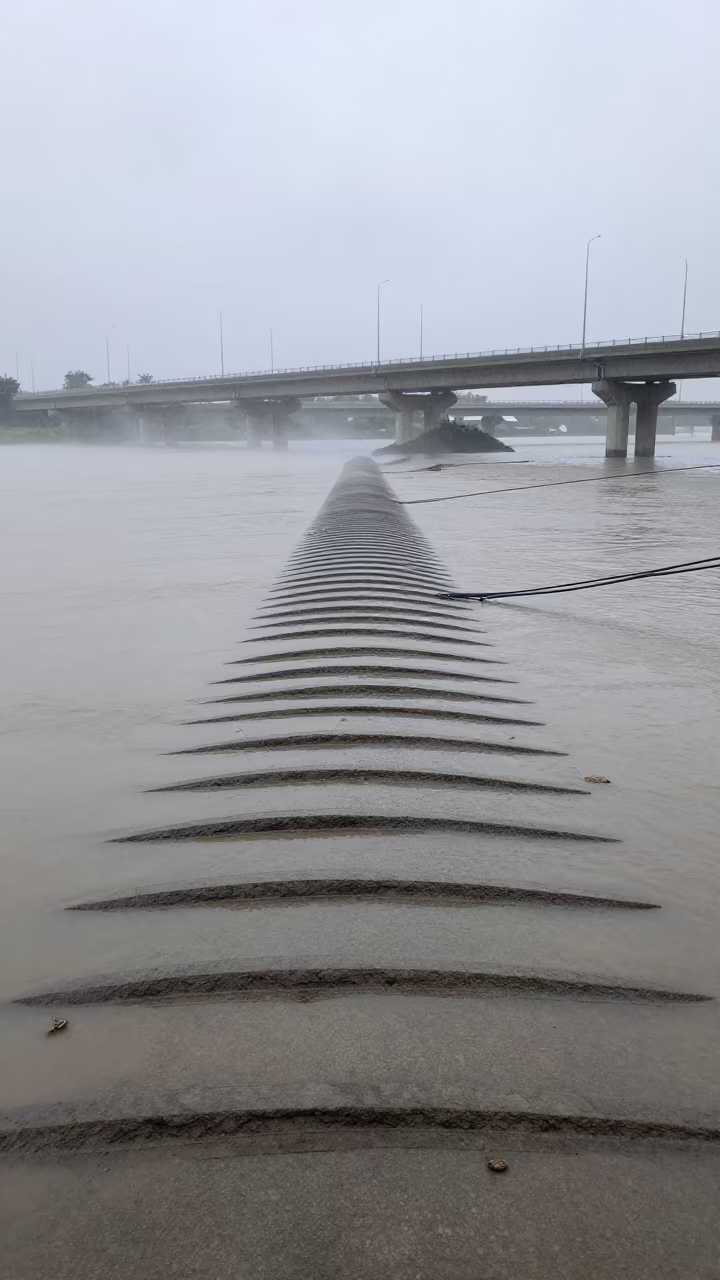 Monsoon Silt Lines on Levee Riprap Under Noon in across a windy overpass interchange near Mancherial