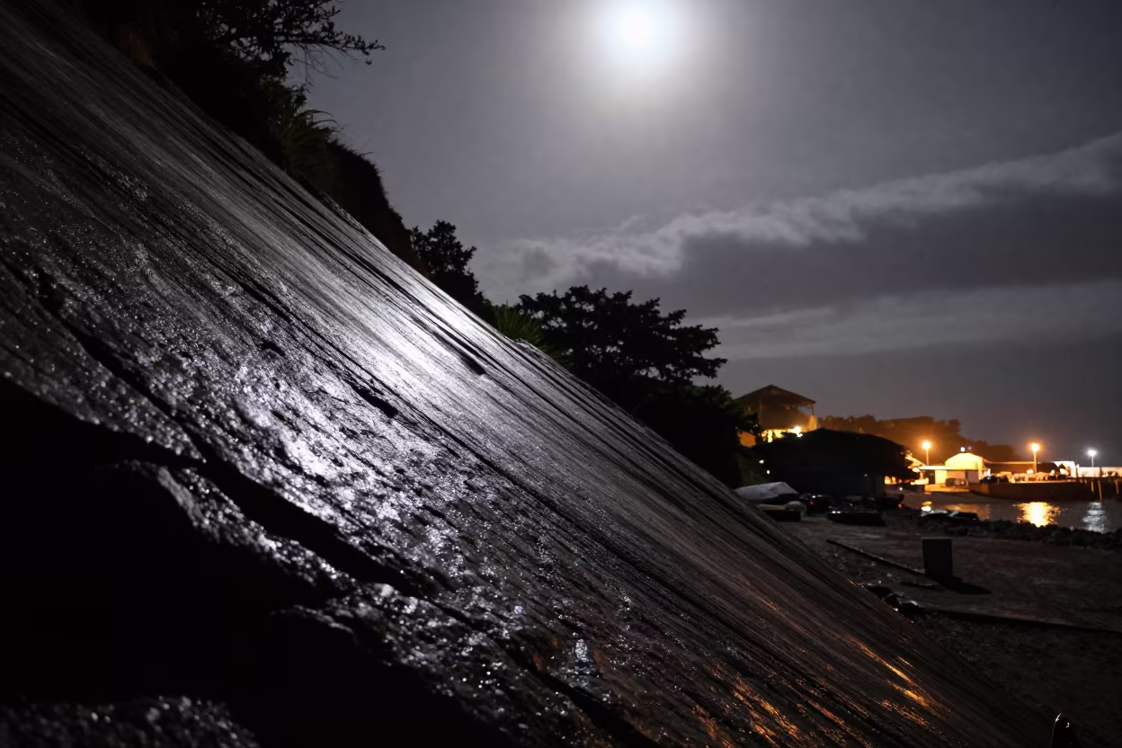 Moonlit Avalanche Chute Striped Shadow Harbor in beside a lantern-dotted harbor in El Salvador