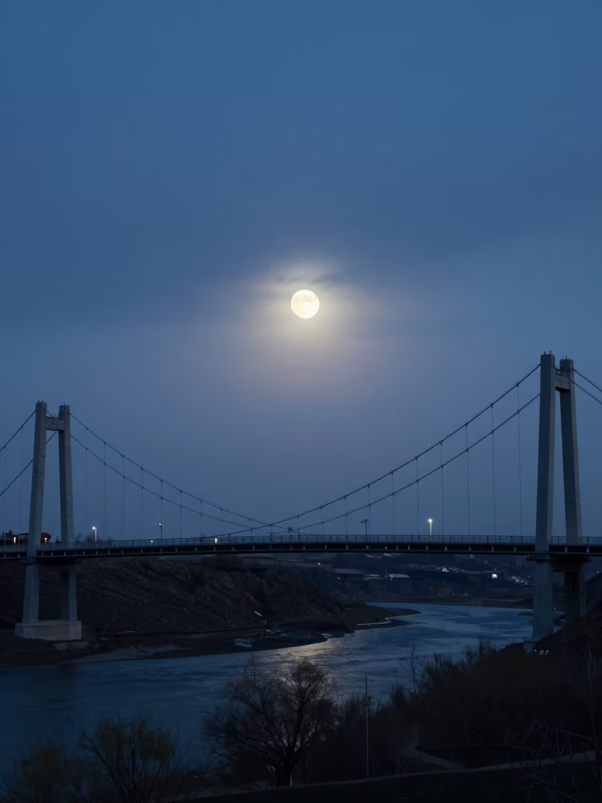 Moonrise Over Suspension Bridge Twilight Kyrgyzstan in under a band of cold starlight in Kyrgyzstan
