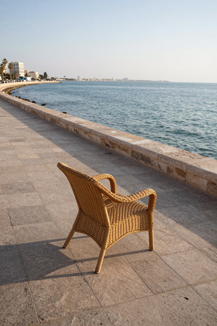 Morning light on Alexandria corniche with deck chair and wicker shadow on tile in in Alexandria, Egypt