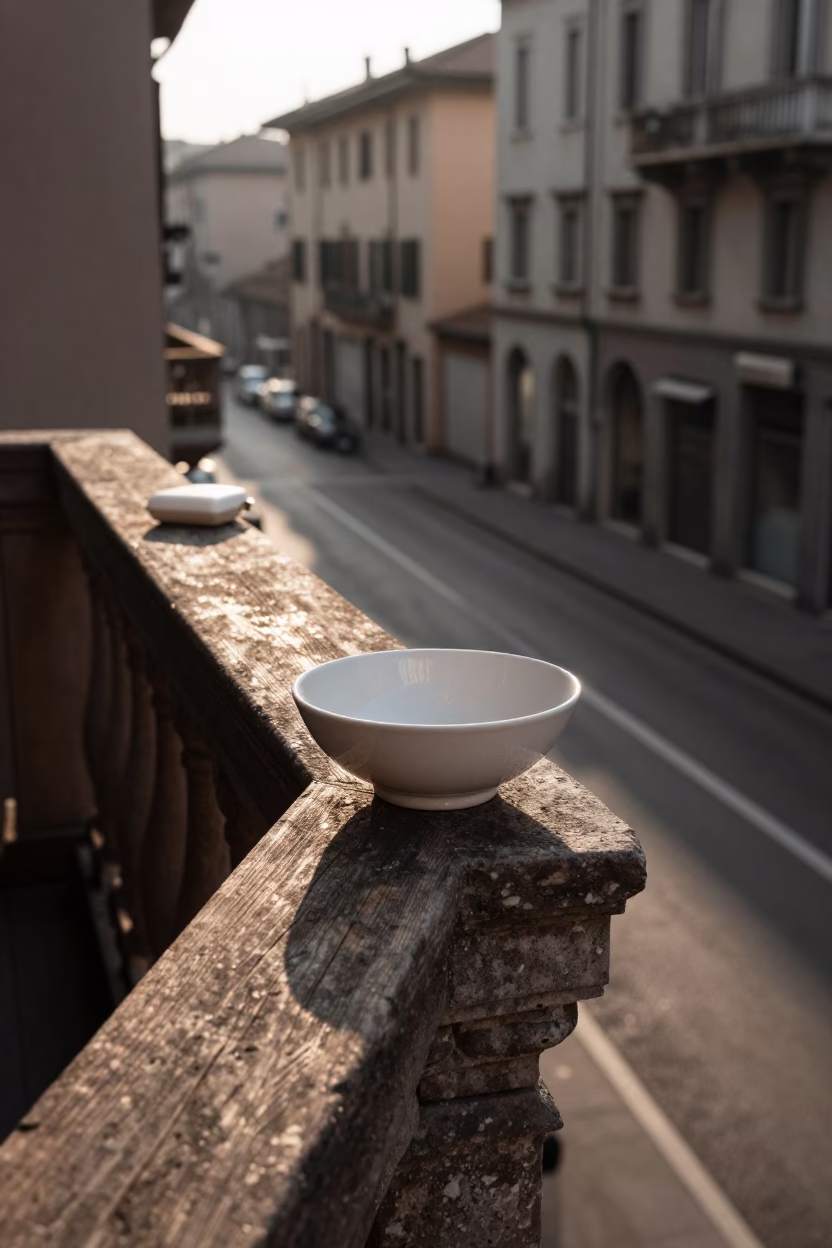 Morning light on Milan street with ceramic bowl and soap case on balcony ledge in in Milan, Italy