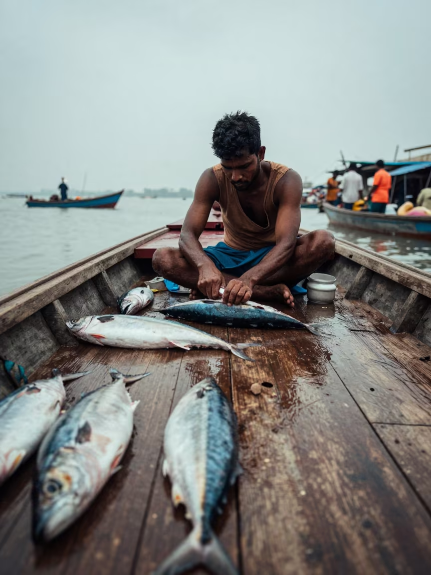 Mumbai Fishmonger Gutting Mackerel on Boat in at a floating market boat in Mumbai