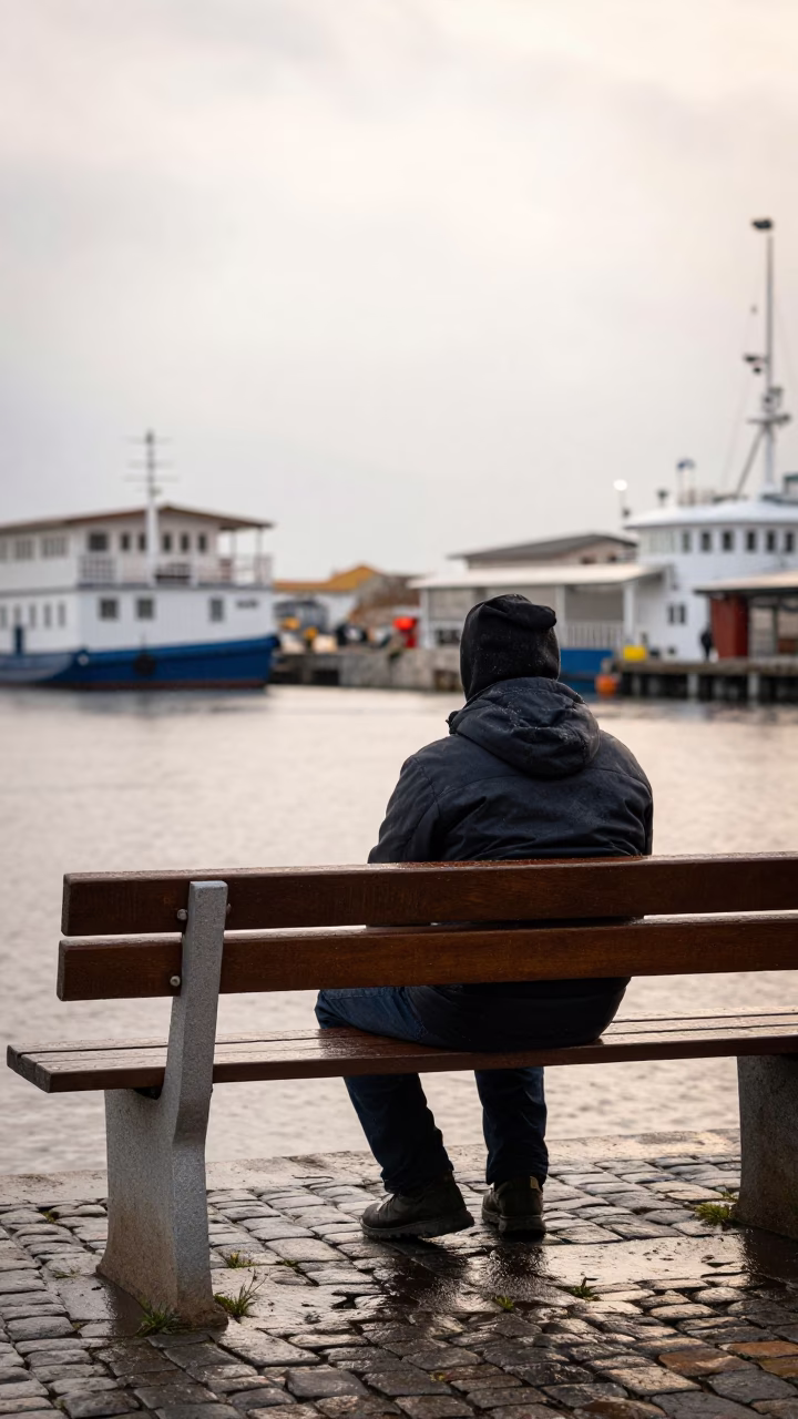 Muralist Resting on Kosti Harbor Bench in Drizzle in at a harbor edge in Kosti