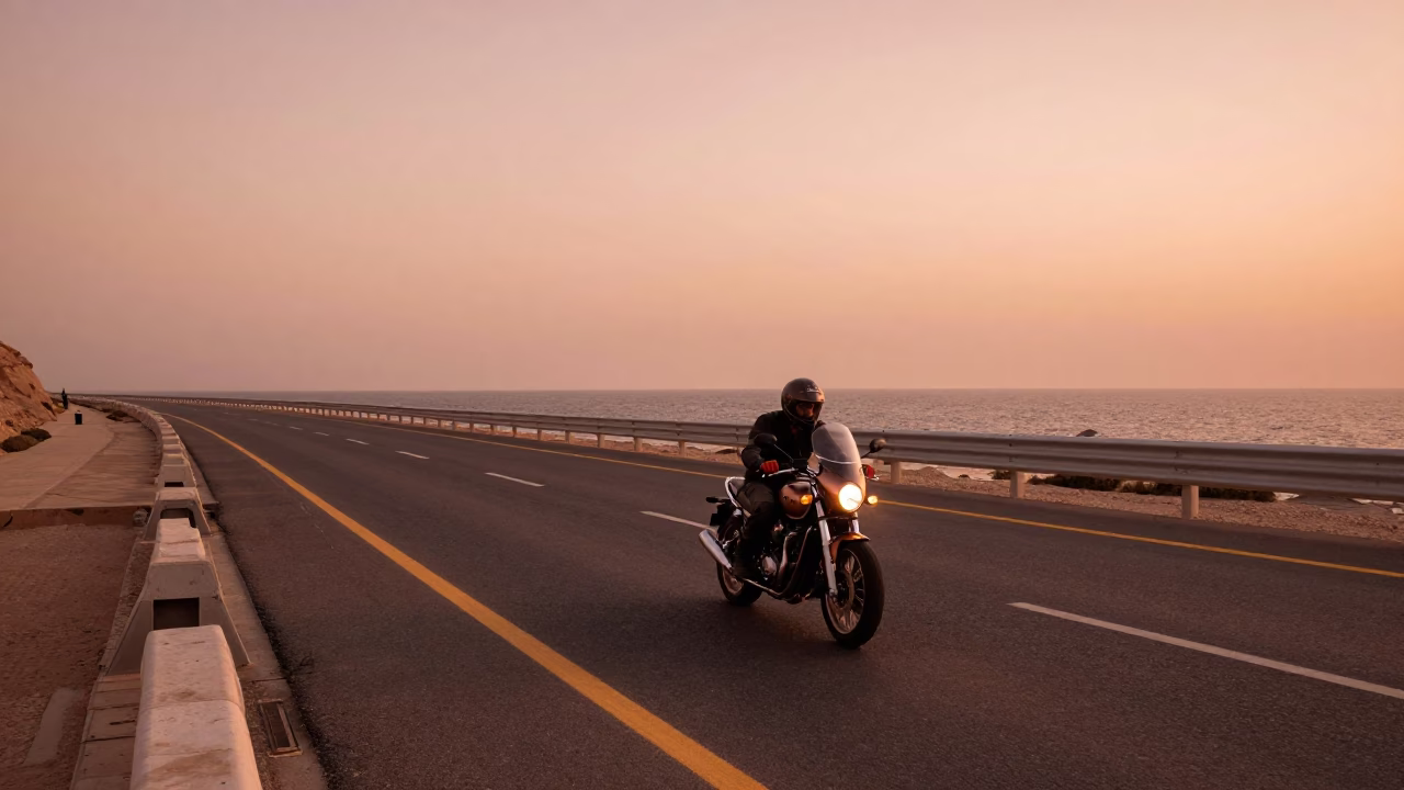Muscat Oman Coastal Highway Motorcycle Rider in Copper Toned Light Before Dusk in in Muscat, Oman