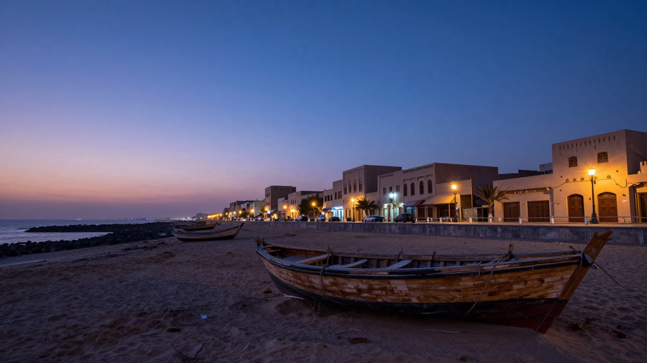 Muscat Oman indigo twilight street scene with traditional dhow boat and coastal architecture in in Muscat, Oman