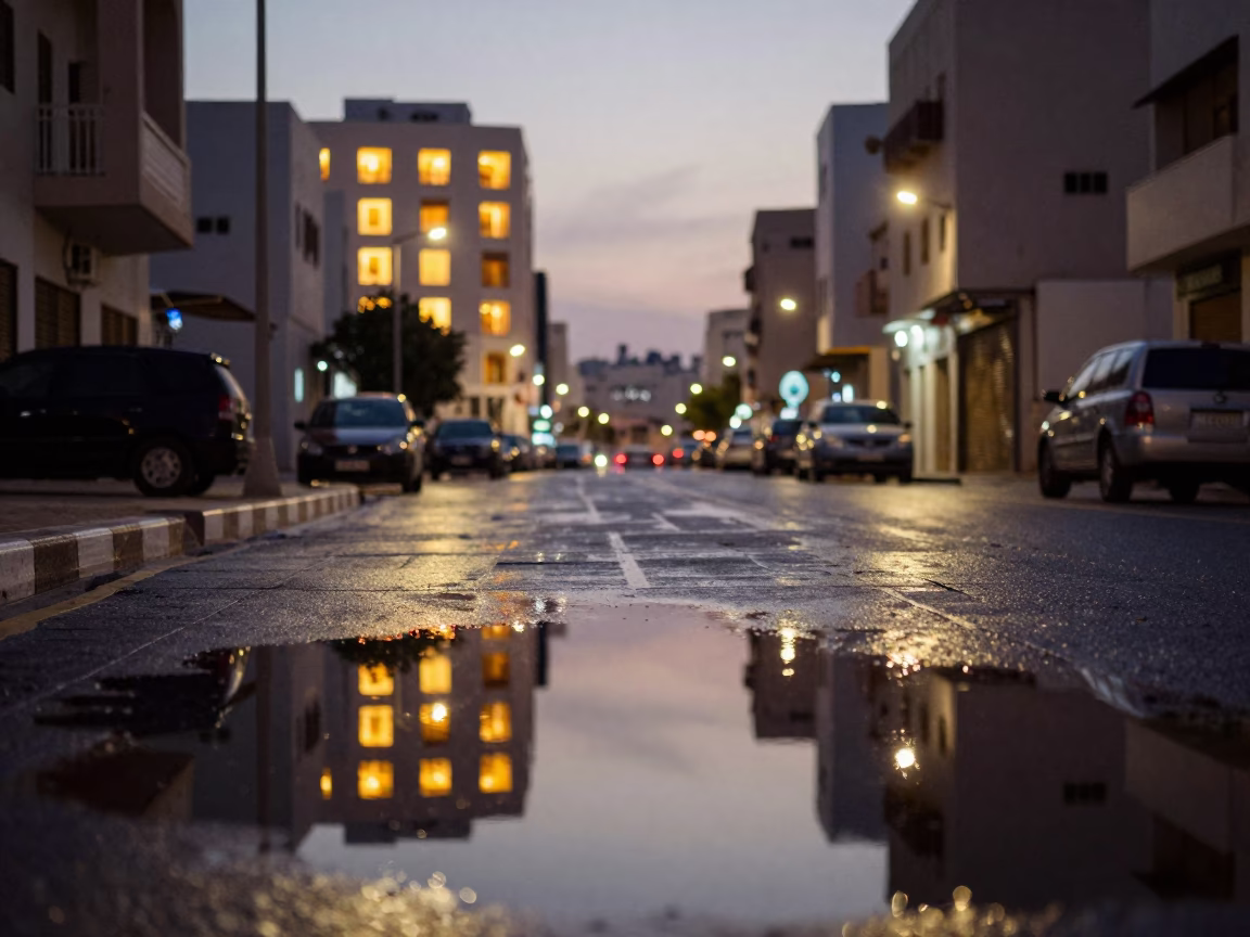 Muscat Oman Street Scene at Dusk with Puddle Reflections and Traditional Architecture in in Muscat, Oman