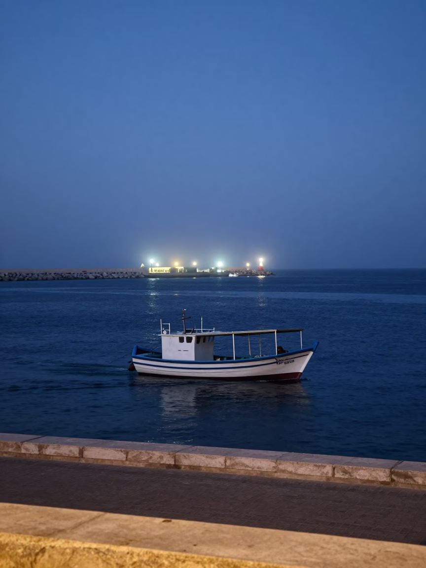 Muscat Oman twilight street scene with fishing boat and harbor beacon in in Muscat, Oman