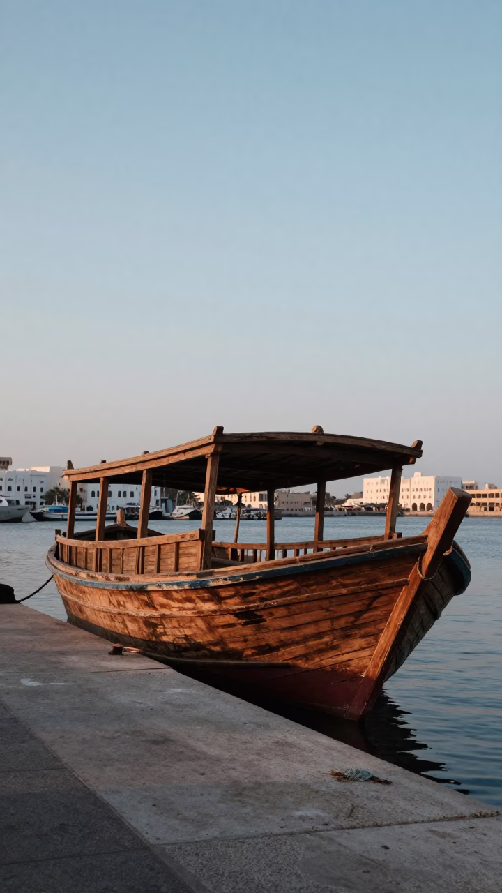 Nautical Dawn Light Illuminates Traditional Muscat Wooden Dhow Boat Docked at Port in in Muscat, Oman