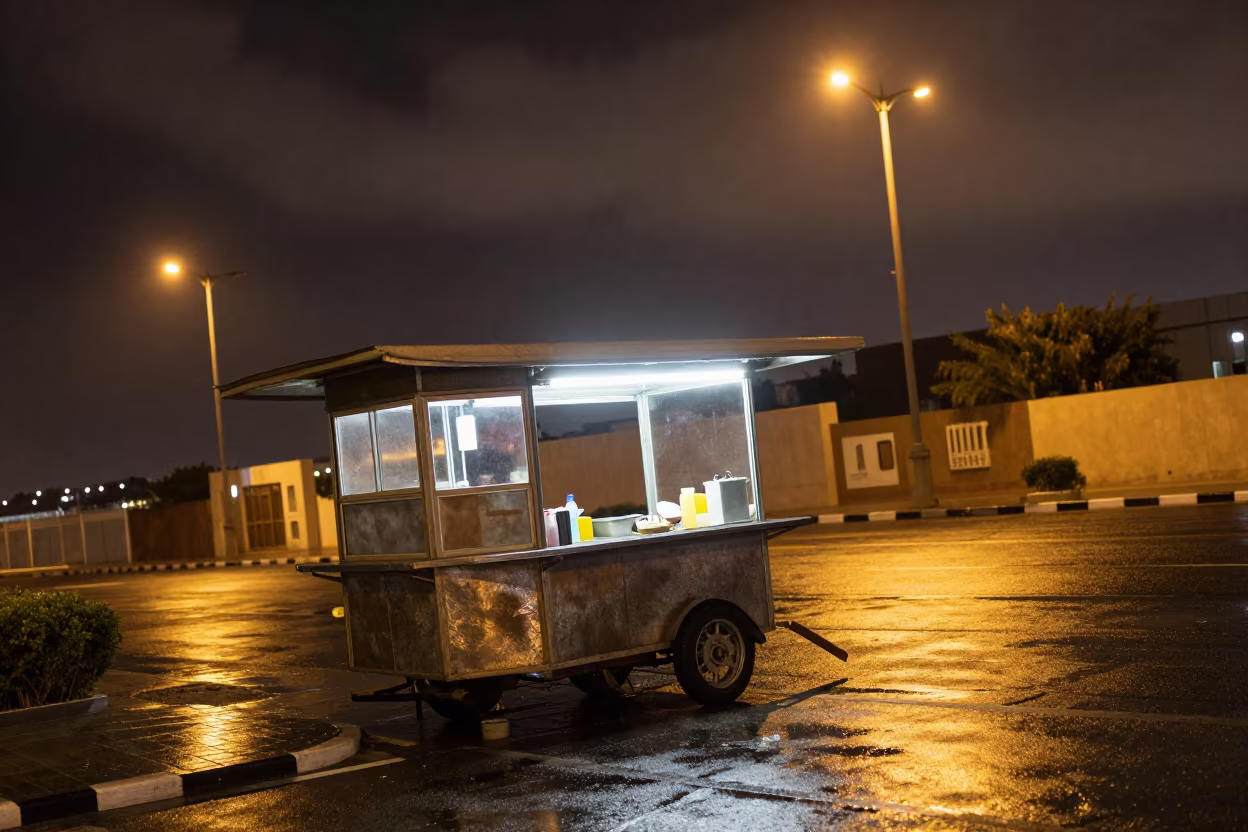Neon Food Cart Rain Night Sohar Street in by a rain-darkened kiosk in Sohar