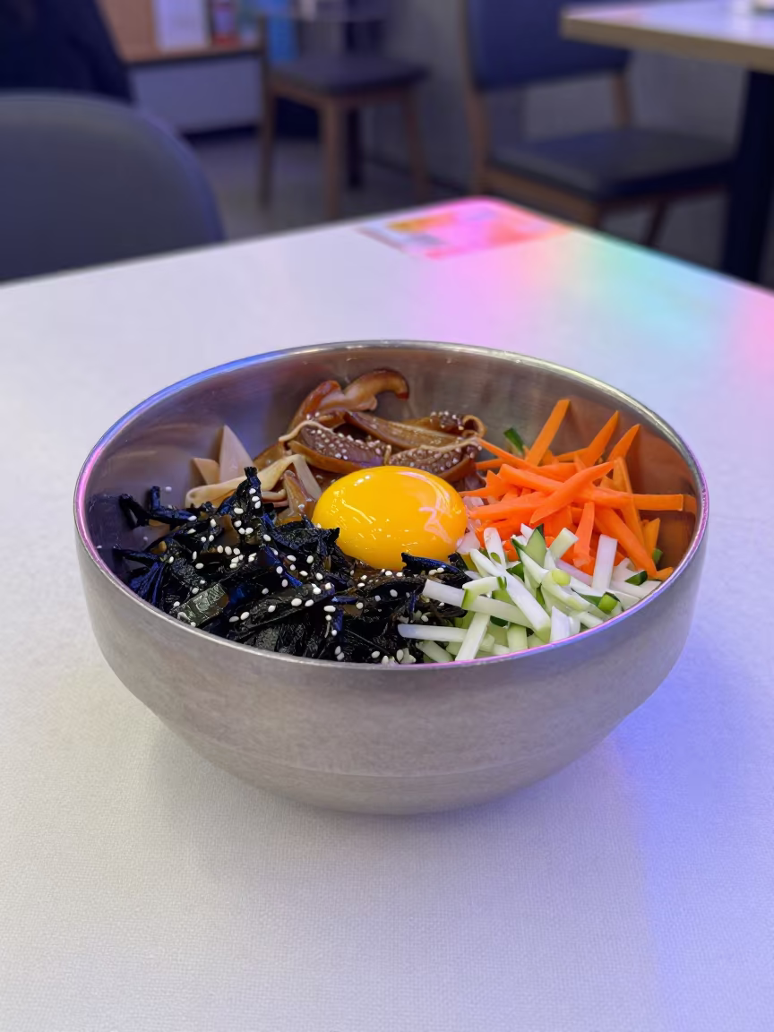 Neon Lit Bibimbap Bowl with Raw Egg in on a linen-covered restaurant table in Sancti Spíritus