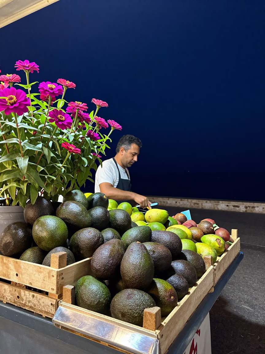 Night Market Stall in Palermo Italy with Fresh Avocados and Zinnias Under Deep Sky in in Palermo, Italy