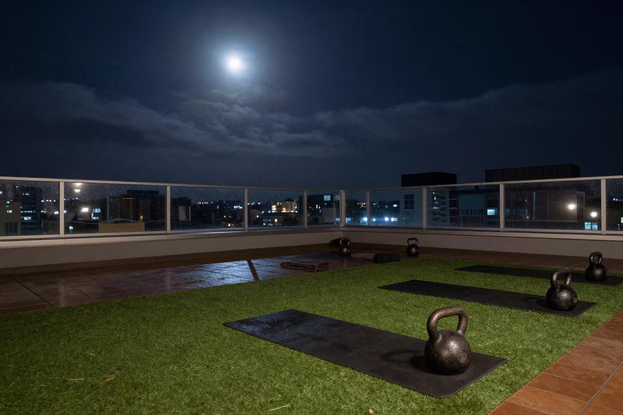 Night rooftop fitness terrace with kettlebells in along a turf bootcamp lane outside the gym near Ica