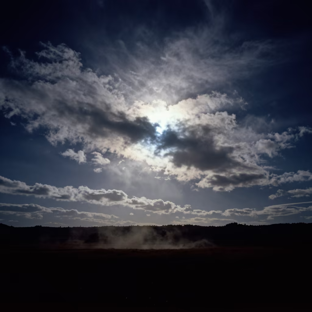 Night Sky Fallstreak Hole Over Spanish Landscape in beneath fast-moving cloud bands in Spain