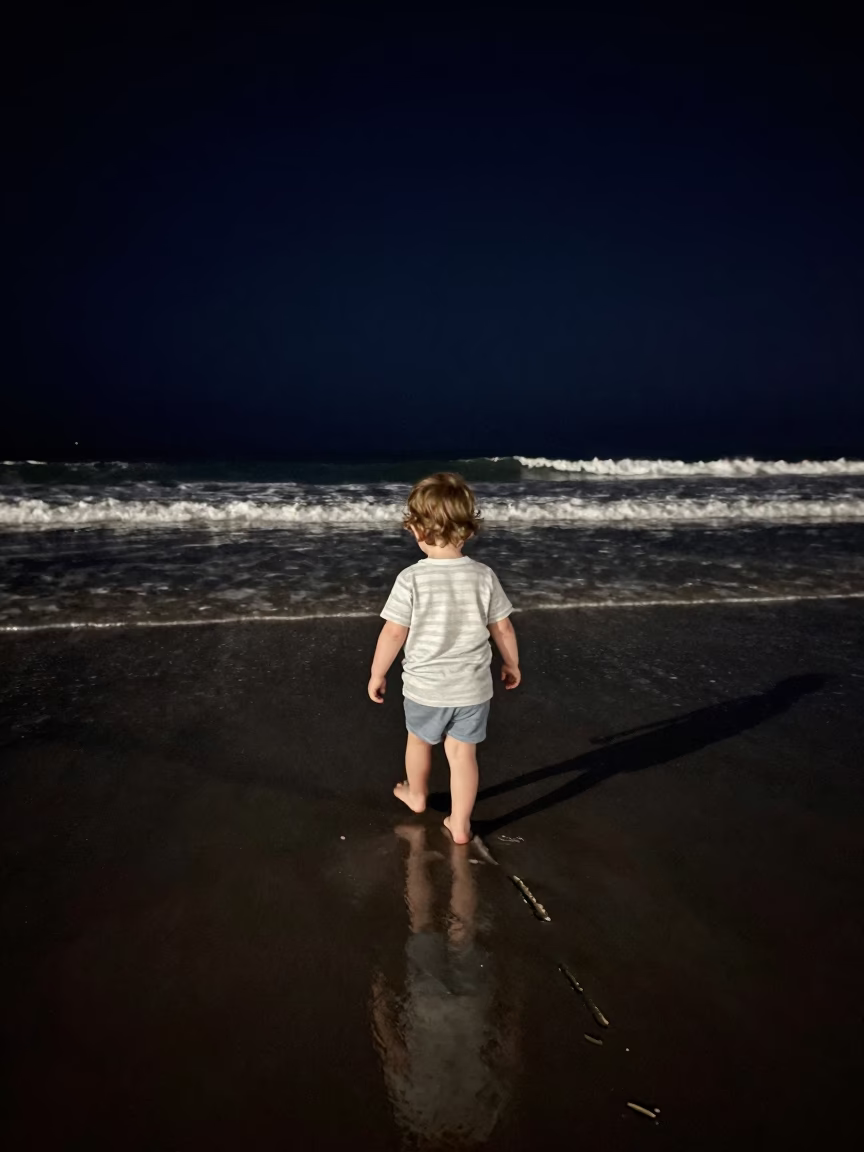 Nighttime Coastal Scene in San Diego California with Toddler Walking on Wet Sand in in San Diego, California, United States
