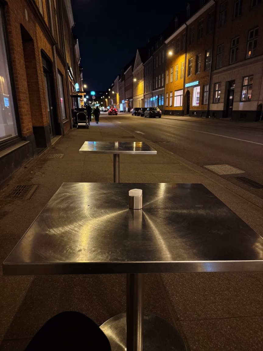 Nighttime Copenhagen Street Scene with Brushed Steel Table and Substation Fence in Denmark in in Copenhagen, Denmark