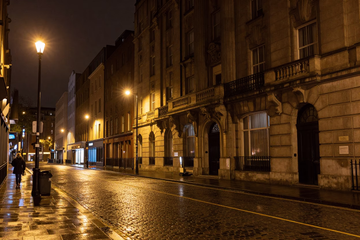 Nighttime Dublin Street Scene with Art Deco Hotel Facade and Wet Cobblestones in in Dublin, Ireland